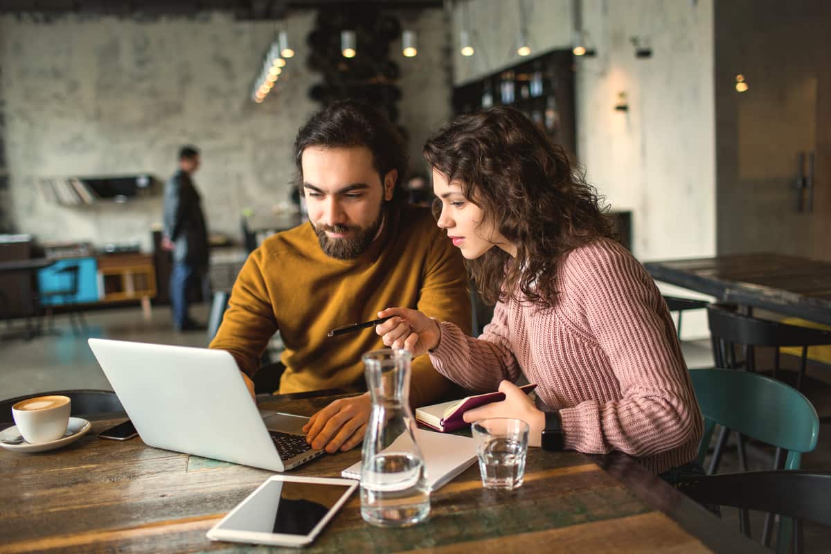 Two people working together over coffee